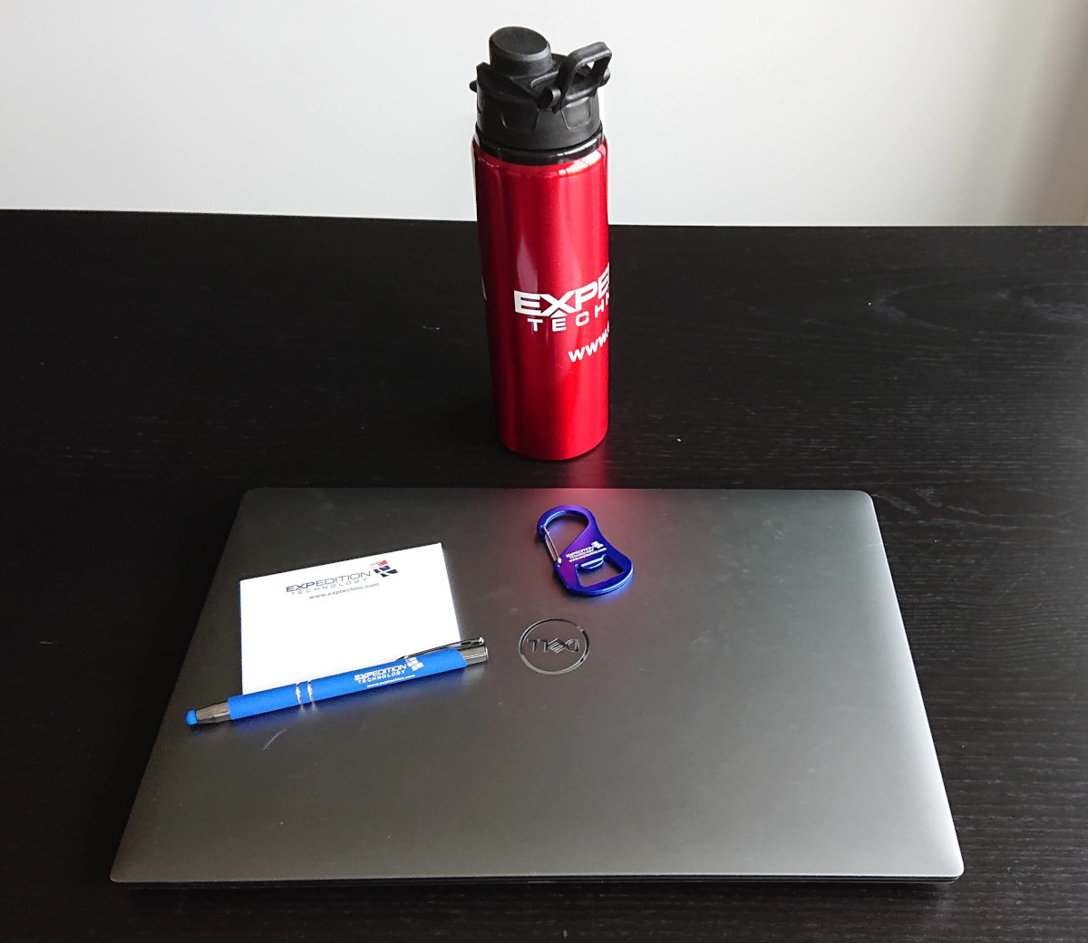 Laptop, EXP water bottle, pen, sticky notes, and carabiner